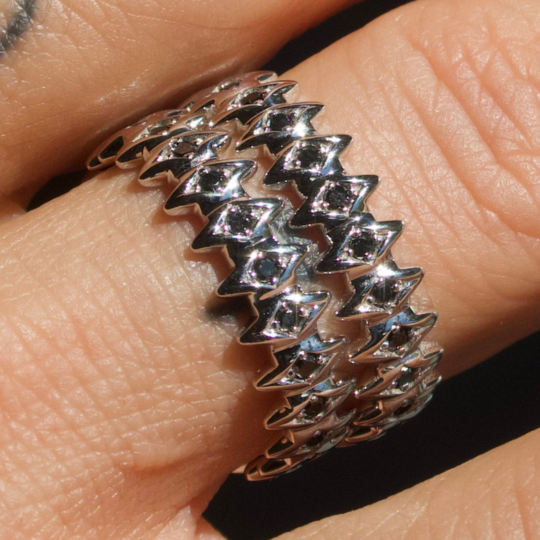 White gold rings with black diamons with zigzag design on a finger