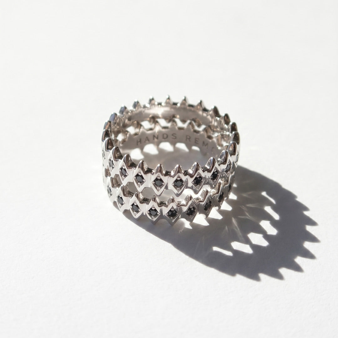 White gold rings with geometric design with black diamonds on a white background