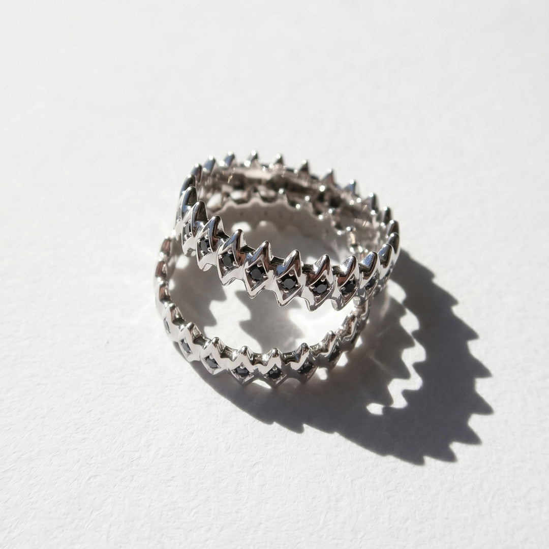 White gold rings with star designs with black diamonds on a white background 