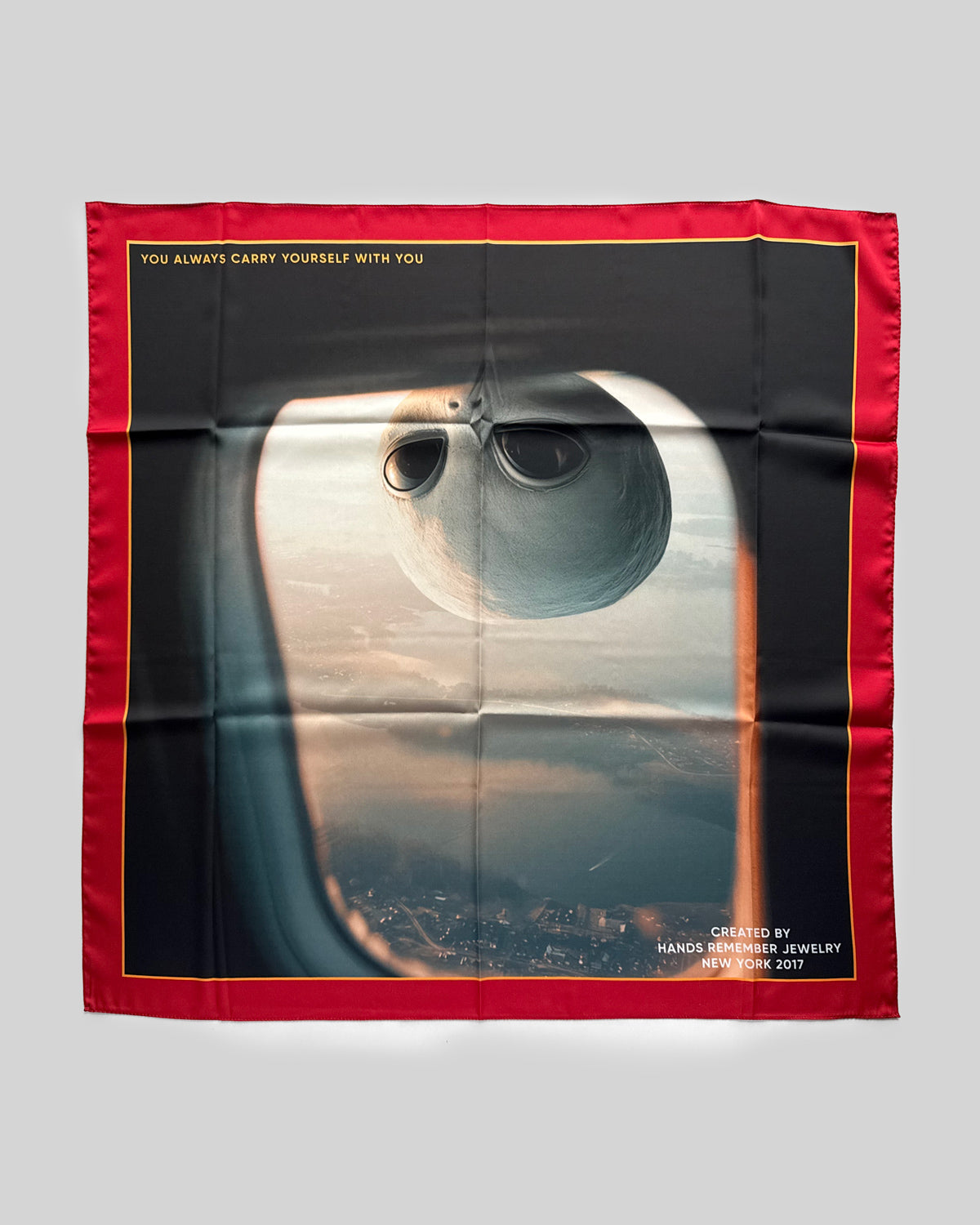 Scarf with a design of a window view from an airplane with an alien