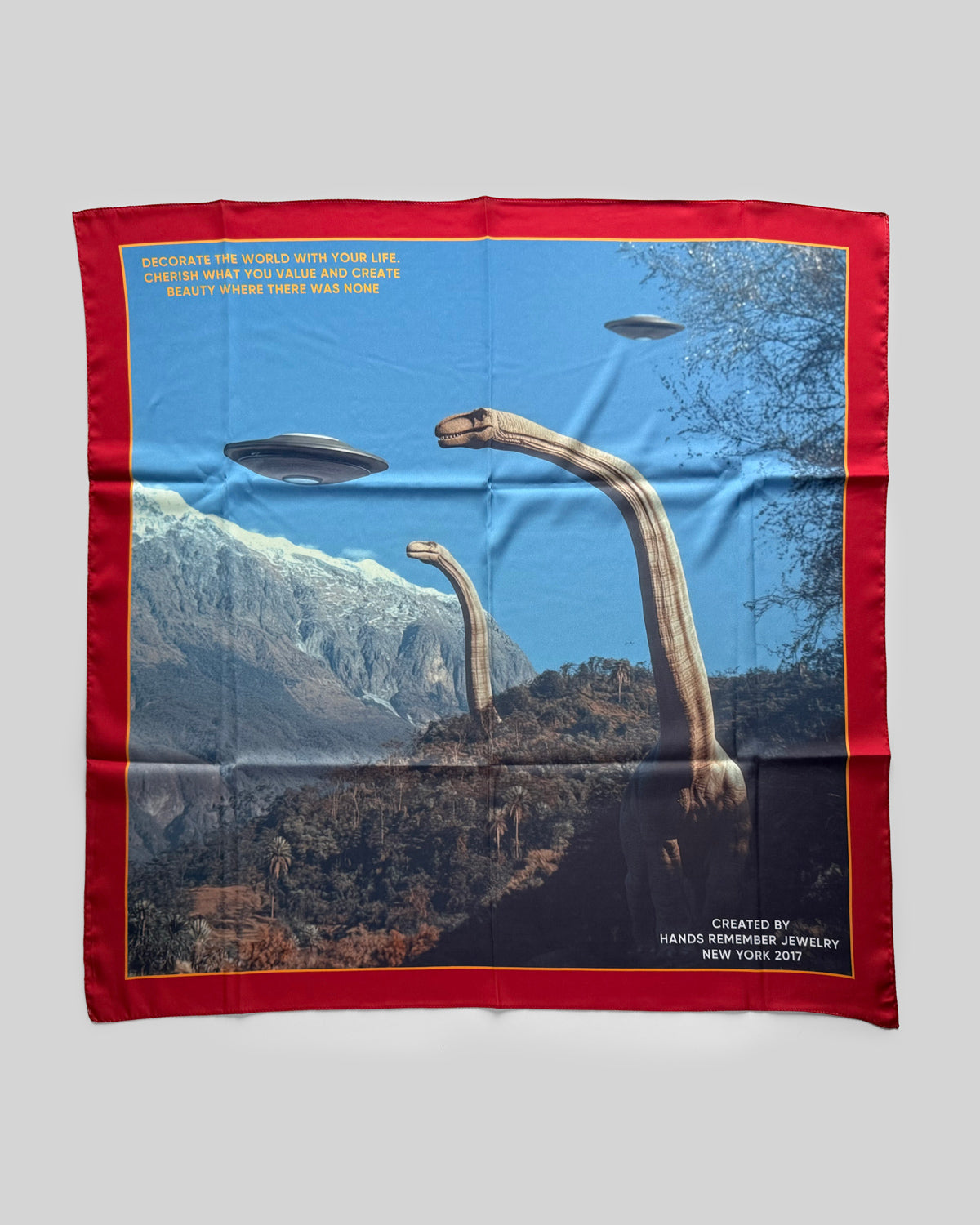 Scarf with UFO design and red border on a gray background