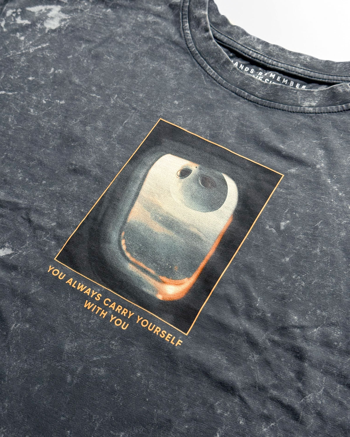 Gray t-shirt with a graphic design and text on a dark background