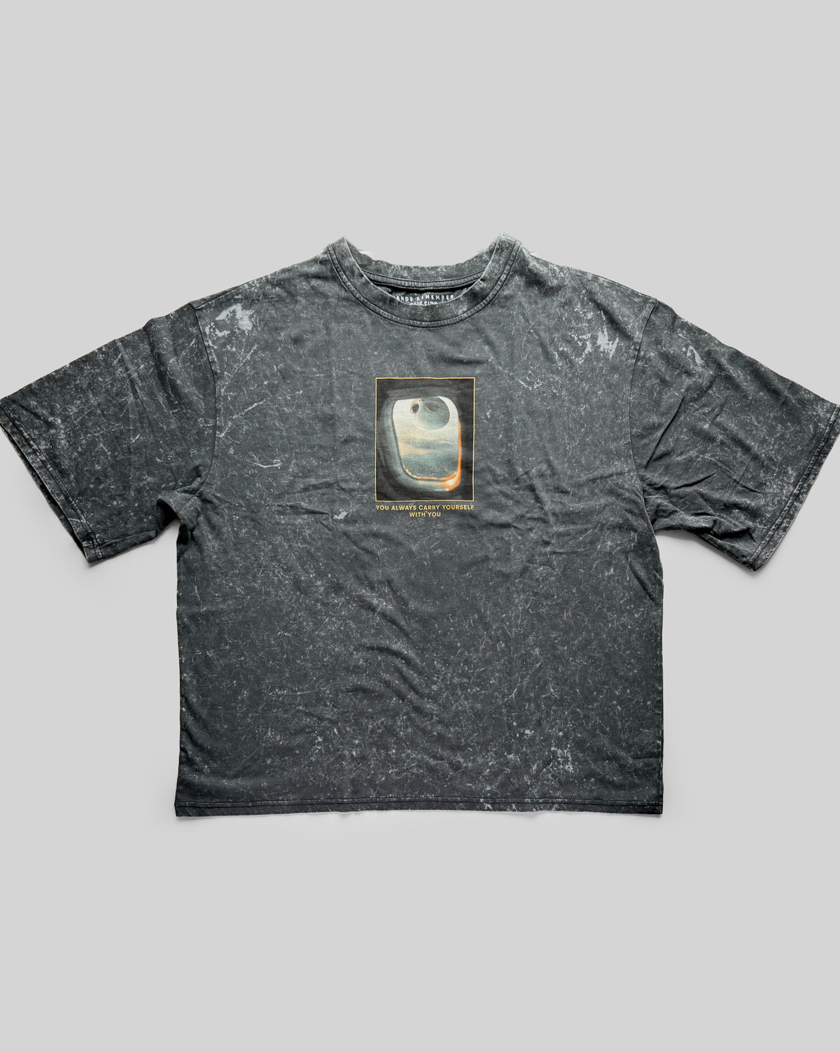 A distressed black t-shirt with a graphic design on a gray background