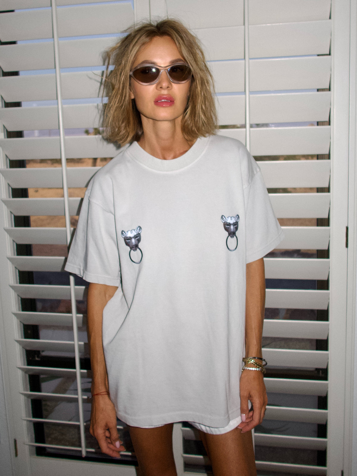 Light grey T-shirt with twin puma graphics and ring details across the chest, front view.
