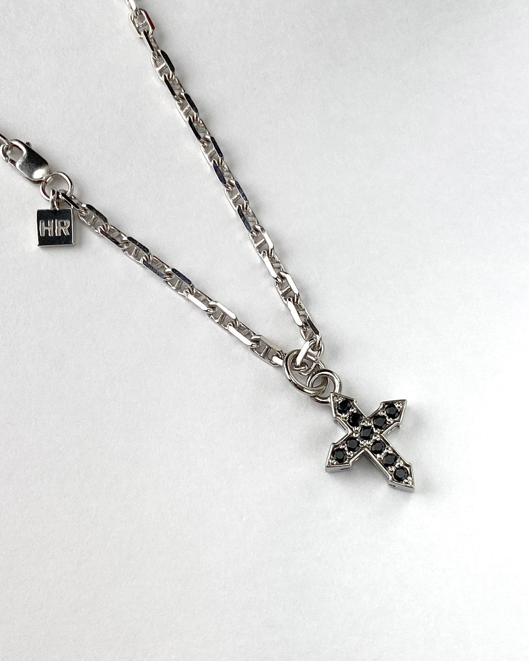 Glow cross pendant with black spinel on a sterling silver chain, full chain view.