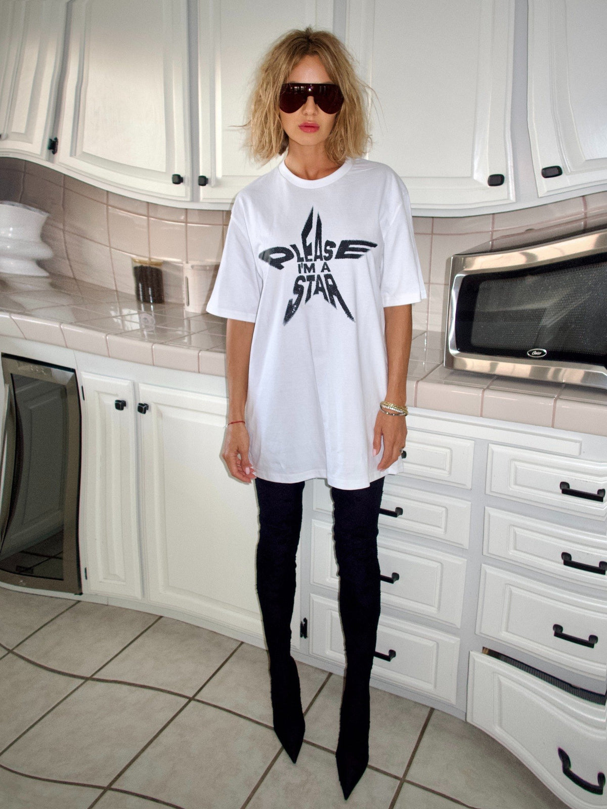 White T-shirt with the “Please, I’m a Star” statement graphic, full-length kitchen view.