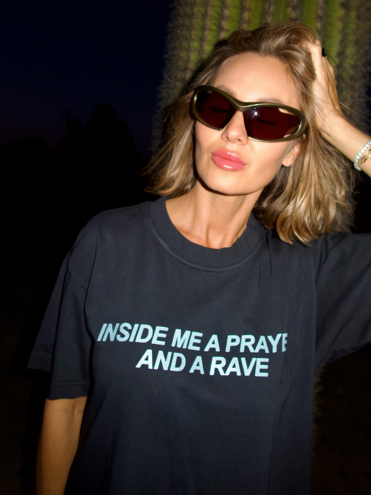 Black T-shirt with the “Inside Me a Prayer and a Rave” print, full-length outdoor view