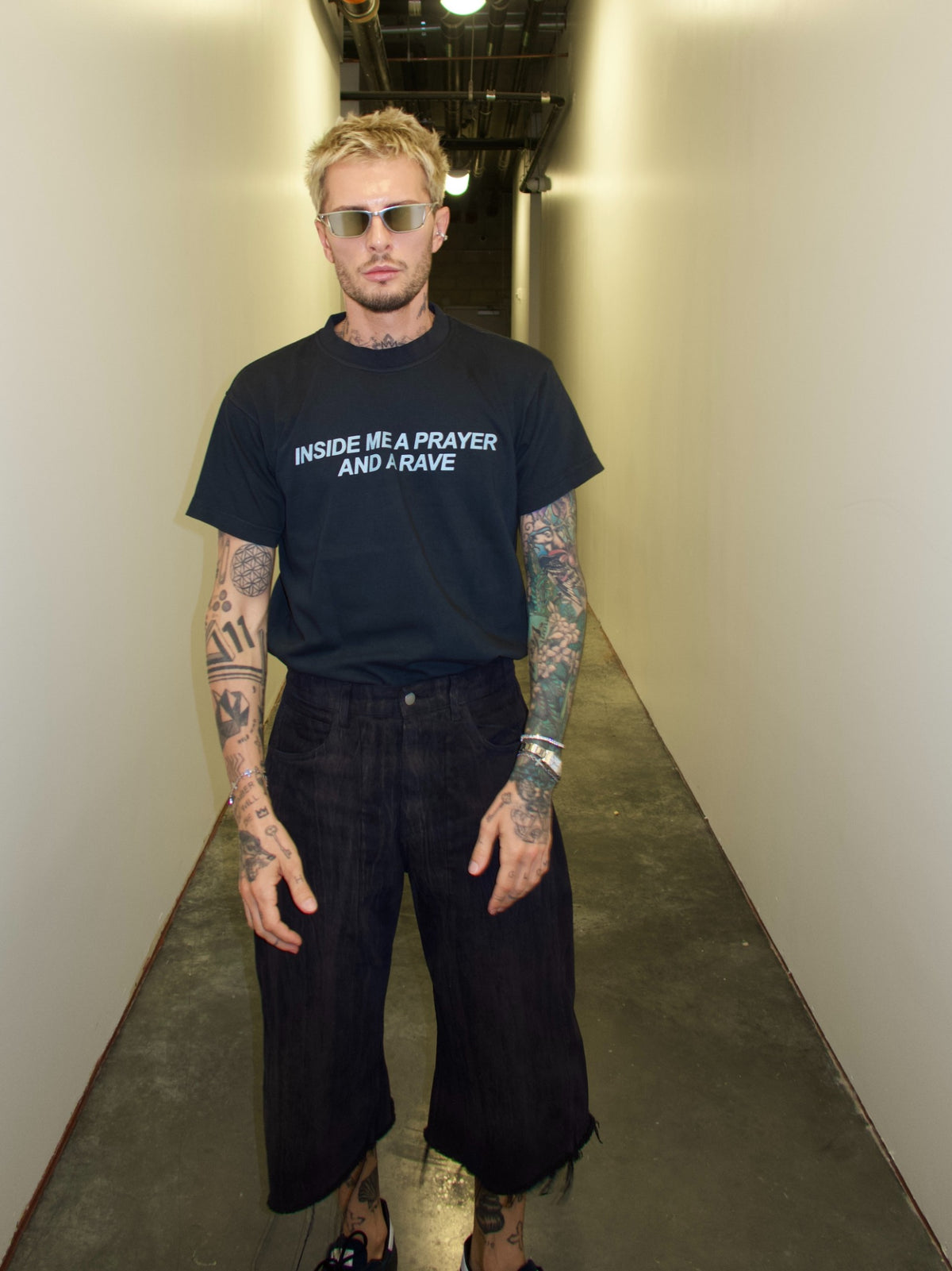 1. Black T-shirt with the “Inside Me a Prayer and a Rave” print, full-length indoor front view.