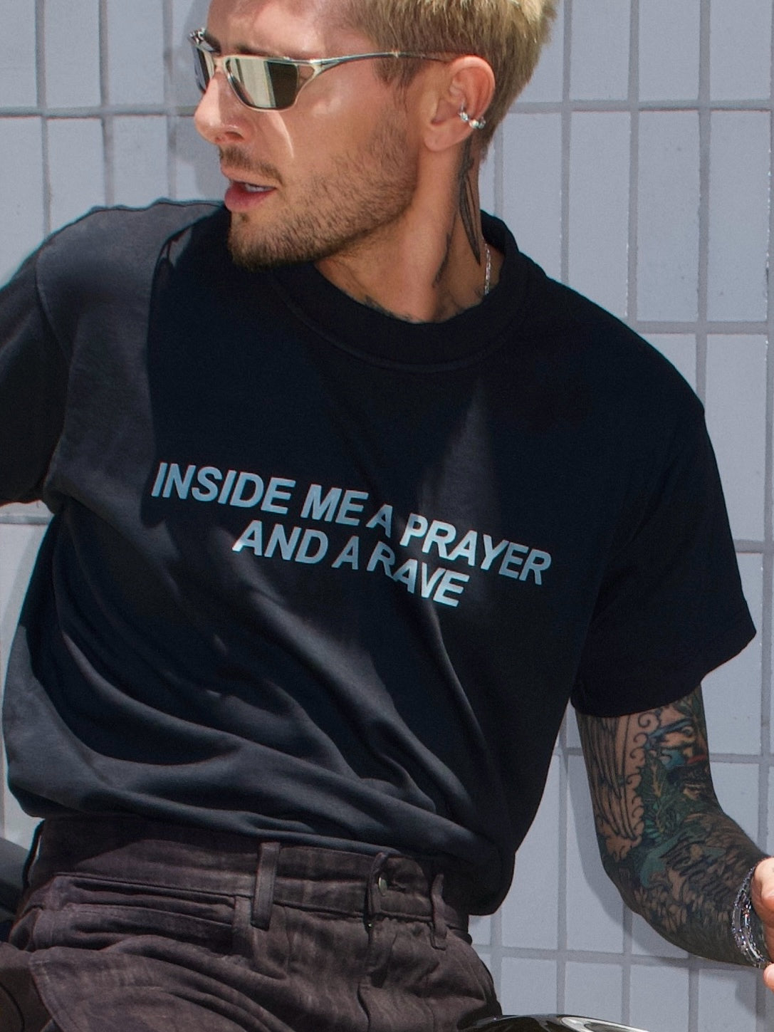 Black T-shirt with the “Inside Me a Prayer and a Rave” print, close-up front view