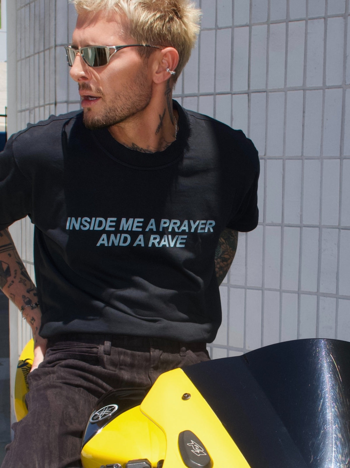 Black T-shirt with the “Inside Me a Prayer and a Rave” print, close-up outdoor portrait